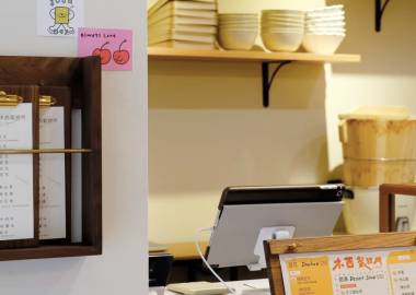 進門處牆面規劃放置菜單的層架，讓客人能自行拿取、點餐。
