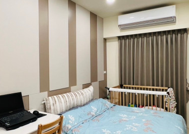主臥床頭以色塊拼貼。床的兩側分別規劃嬰兒床與書桌區域。