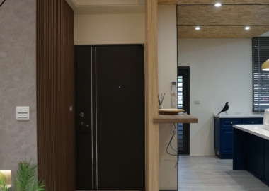 進門處右側配置了小儲藏室，以具藝術造型的實木格柵板做隱藏設計。