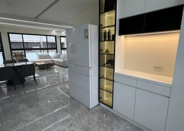 廚具對面規劃廚櫃可收納藏酒與廚房用品，檯面可放置小家電方便使用。